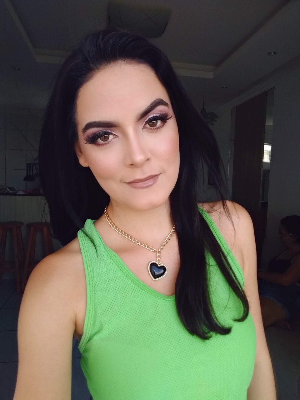 Olho esfumado com cílios postiços, pele iluminada e boca em tom nude.